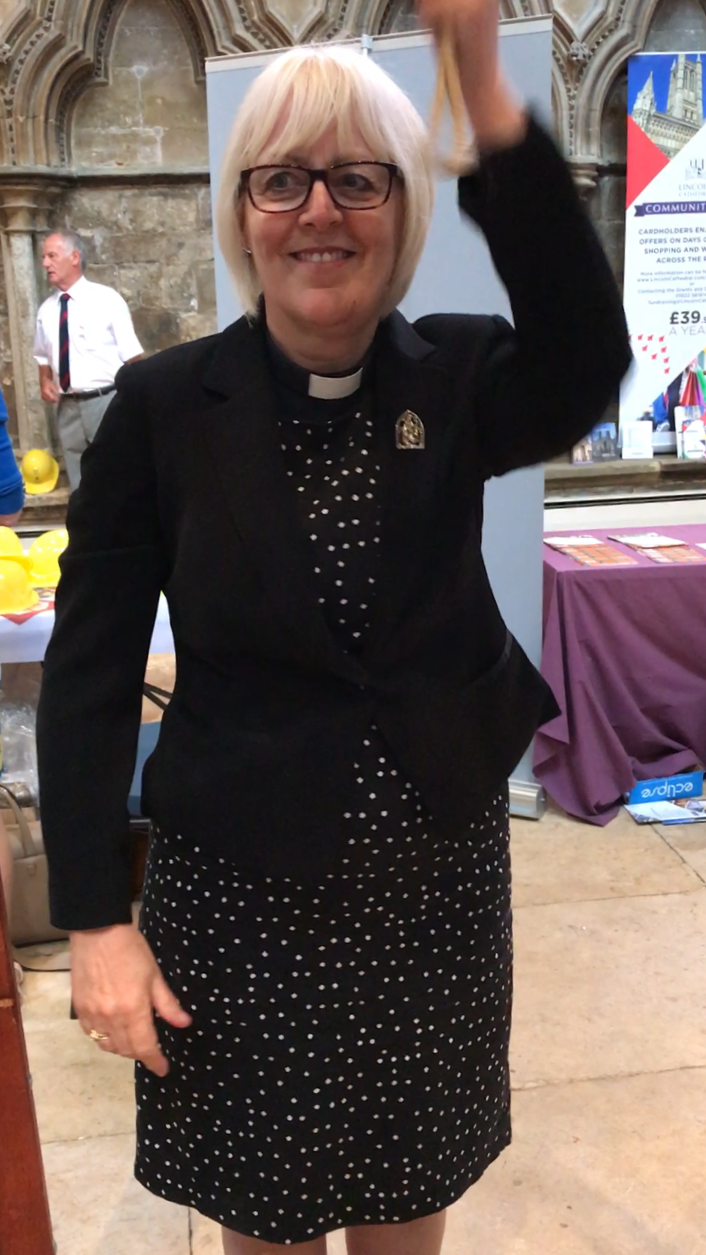 Vicar ringing a bell at a mini-ring